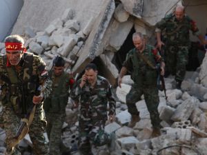 Syrian pro-government soldiers patrol the Uwaija neighborhood as they advance in Aleppo's rebel-held areas. (AFP/George Ourfalian)