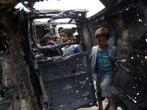 Yemeni children inspect a charred vehicle on September 9, 2016 after two improvised explosive devices (IEDs) went off inside a car in the capital Sanaa. (AFP/Mohammed Huwais)