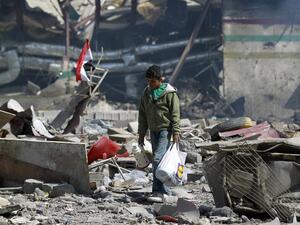 A Yemeni boy walks amid the ruins of a school and a bowling club hit by an air-strike carried out by the Saudi-led coalition, in the capital Sanaa, on February 12, 2016. (AFP/Mohammed Huwais)