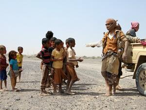 Pro-government fighters give food to Yemeni children on the road leading to the southwestern port city of Mokha on January 26, 2017. (AFP/Saleh al-Obeidi)