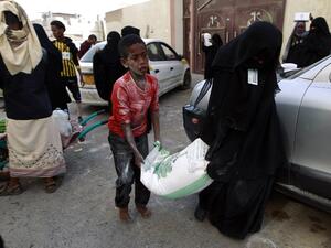 Yemenis affected by the country's ongoing conflict receive food rations provided by an initiative organized by a local charity in the capital Sanaa on June 2, 2016. (AFP/Mohammed Huwais)