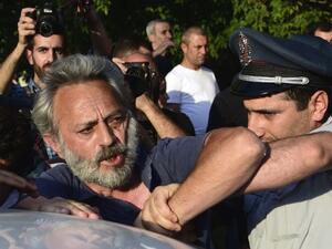 Armenian police detain an opposition supporter, artist Nikol Aghababyan, next to a police check point blocking the streets to Erebuni police station in Yerevan on July 17, 2016. (AFP/Karen Minasyan)