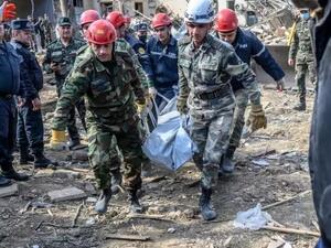 رجال انقاذ يحملون جئة ضحية جراء قصف في غاندجا في أذربيجان