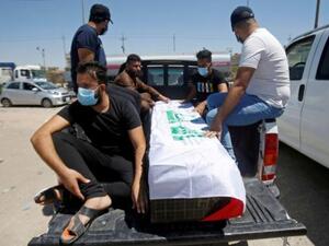 مشيعون يجلسون أمام نعش الناشطة العراقية ريهام يعقوب خلال جنازتها في البصرة