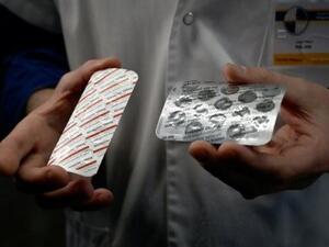 عنصر طبي في المعهد المتوسطي للأمراض المعدية في مارسيليا بجنوب فرنسا يعرض أقراصا من دواء نيفاكين الذي يحتوي على مادة الكلوروكين