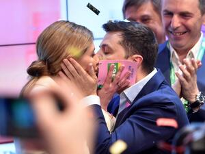 Ukrainian comedian and presidential candidate Volodymyr Zelensky kisses his wife Olena after the announcement of the first exit poll results in the second round of Ukraine's presidential election at his campaign headquarters in Kiev on April 21, 2019.  Sergei GAPON / AFP
