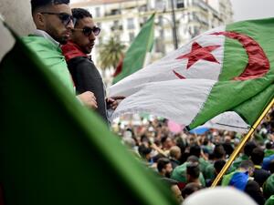 Algerian protesters wave a national flag as they take part in a demonstration in the capital Algiers (AFP)