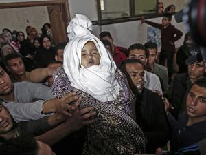 Palestinian mourners carry the shrouded body of Saba Abu Arar during her funeral in Gaza City (AFP)