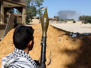 A fighter loyal to the internationally recognised Libyan Government of National Accord (GNA) holds a rocket propelled grenade launcher as he keeps position (AFP)