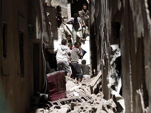 Yemenis sift the rubble of a heavily damaged building following reported Saudi-led coalition air strikes in the Yemeni capital Sanaa (AFP)