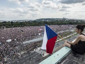 A woman holds a Czech flag during a rally demanding the resignation of Czech Prime Minister Andrej Babis (AFP)