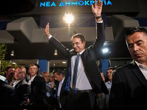 Greece's newly elected Prime Minister and leader of conservative New Democracy party Kyriakos Mitsotakis, waves at his supporters outside the party's headquarters after the official results of the elections, in Athens  (AFP)