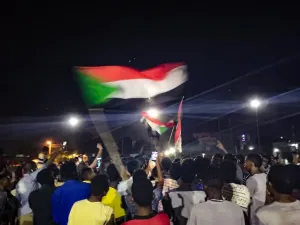 Sudanese demonstrators wave national flags as they protest in the streets of the capital Khartoum to demand civilian rule  (AFP)