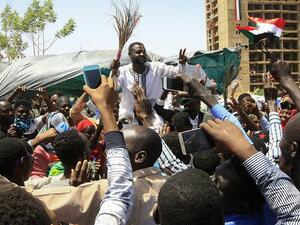 Young Sudanese rally to celebrate after an announcement made by Sudan's new military ruler, outside the army headquarters in the Sudanese capital Khartoum, on April 13 (AFP)