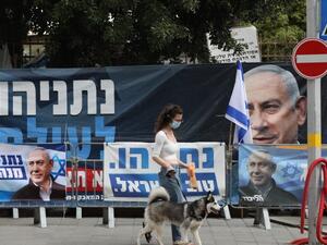 فتاة اسرائيلية امام يافطات الدعاية الانتخابية