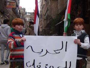 طفلان خلال مسيرة بمخيم اليرموك تطالب بالإفراج عن المعتقلين الفلسطينيين-صورة أرشيفية
