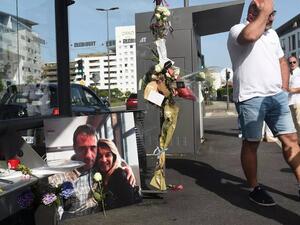 رجل يمر أمام صورة فيليب مونغيو سائق الحافلة القتيل وزوجته فيرونيك في مدينة بايون جنوبي غرب فرنسا