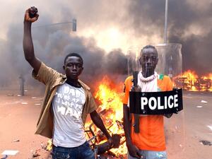 Protesters pose with a police shield outside the parliament in Ouagadougou on October 30, 2014 /AFP