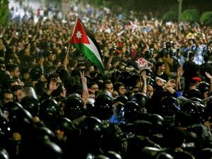 Protesters demonstrate outside the prime minister's office in Amman late on June 2, as security forces stand on alert /AFP