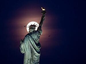 Full moon rises behind the Statue of Liberty in New York City, 2019 /AFP