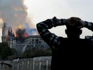 Anxious passers-by watched the landmark cathedral burn (AFP/Geoffroy VAN DER HASSELT)