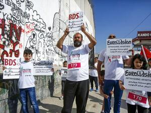 Activists hold banners calling for the boycott of Eurovision in the biblical town of Bethlehem in the occupied West Bank on 22 March 2019 [Musa AL ShaerAFP]