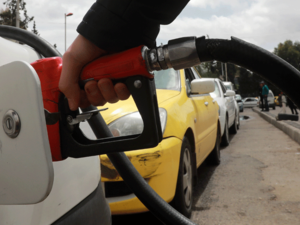 A driver fills his car with gasoline after queueing in front of a petrol station in the Syrian capital Damascus. 