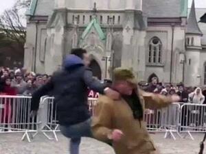 Screenshot of a video showing a young man kicking a person who tries to burn the Holy Quran during an anti-Islam rally in Norway