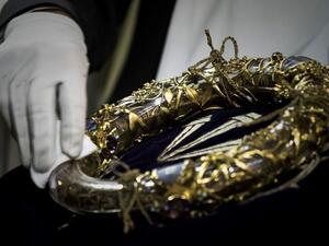 In this file photo taken on April 14, 2017 shows a priest wiping the Crown of Thorns, a relic of the passion of Christ- at the Notre-Dame Cathedral in Paris. Philippe Lopez / AFP