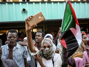 Sudanese demonstrators welcome fellow protesters from the city of Atbara with cheers and national flags as their train arrives at the Bahari station in Khartoum on April 23, 2019. OZAN KOSE / AFP
