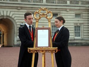 Footmen Stephen Kelly and Sarah Thompson set up an official notice on an easel at the gates of Buckingham Palace in London on May 6, 2019, announcing the birth of a son to Britain's Prince Harry, Duke of Sussex and Meghan, Duchess of Sussex. (AFP/ File Photo)