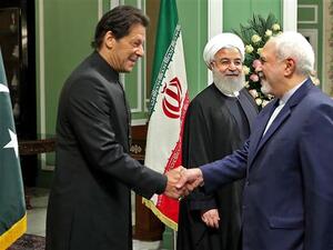 Iranian Foreign Minister Mohammad Javad Zarif (R) welcoming Pakistani Prime Minister Imran Khan as President Hassan Rouhani looks on, in Tehran. (AFP)