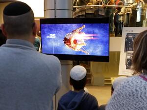 People watch a screen showing explanations of the landing of Israeli spacecraft, Beresheet's, at the Planetaya Planetarium in the Israeli city of Netanya, on April 11, 2019. (JACK GUEZ / AFP)