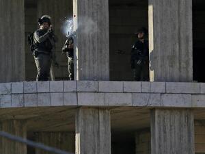 An Israeli soldier fires a tear gas canister at Palestinian stone throwers following a raid in the West Bank city of Ramallah. (AFP)