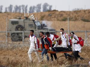 Palestinian paramedics carry a man on a stretcher during a demonstration near the border with Israel, east of Khan Yunis in the southern Gaza Strip, on April 26, 2019. (Said KHATIB / AFP)