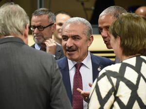 Palestinian Prime Minister Mohammad Shtayeh (C) talks with EU Commissioner for Enlargement Negotiations Johannes Hahn (L). (AFP/ File Photo)