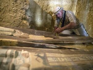 An excavation worker works inside a burial shaft at the Giza pyramid plateau, on the southwestern outskirts of the Egyptian capital Cairo, on May 4, 2019, following the discovery of several Old Kingdom tombs and burial shafts. (MAHMOUD KHALED / AFP)