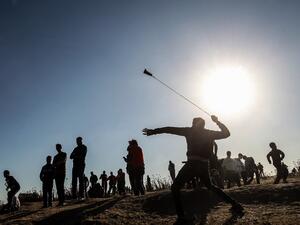 A Palestinian protester hurls stones at Israeli troops during a demonstration near the border with Israel, east of Gaza City, on May 10, 2019. (Said KHATIB / AFP)