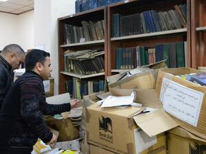 Iraqi men sort out books at the new library of Mosul University in Iraq's northern city of Mosul on April 17, 2019. (AFP)