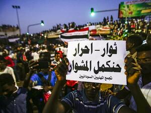 A Sudanese protester holds up a sign reading in Arabic "revolutionaries, free, will continue the course", during a late demonstration demanding a civilian body to lead the transition to democracy. (ASHRAF SHAZLY / AFP)