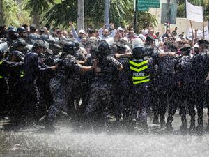 Striking teachers are pushed back by police in Sep 2019 (AFP/FILE) banner image