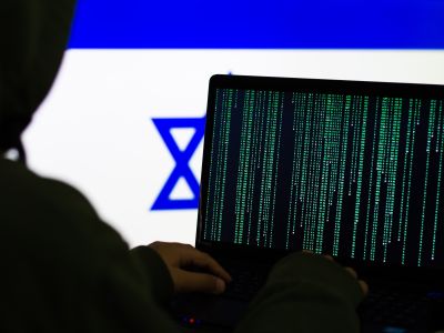 Computer Hacker in front of flag