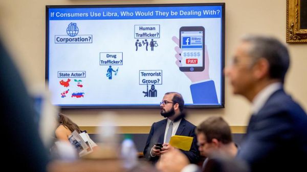  A screen the reads "If Consumers Use Libra, Who Would They Be Dealing With?" is displayed with questions on potential user actors as David Marcus, CEO of Facebook's Calibra digital wallet service, foreground, appears before a House Financial Services Committee hearing on Facebook's proposed cryptocurrency on Capitol Hill in Washington, Wednesday, July 17, 2019.