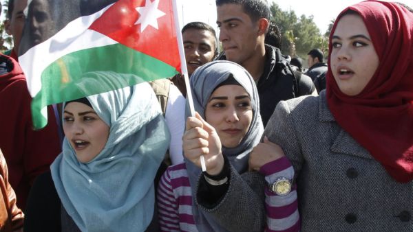 Jordanian girls wave the flag of Jordan.