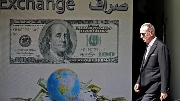 A man walks past a money exchange in Beirut after Lebanon's central bank announced measures to facilitate access to dollars for importers of petroleum products, wheat, and medicine amid fears of a dollar shortage.