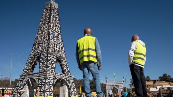 "Yellow Vest" movement protestors look at a 11,5 meter Eiffel Tower replica they made of 135 wood pallets on the roundabout of Le Luc, southeastern France. (AFP/ File Photo)