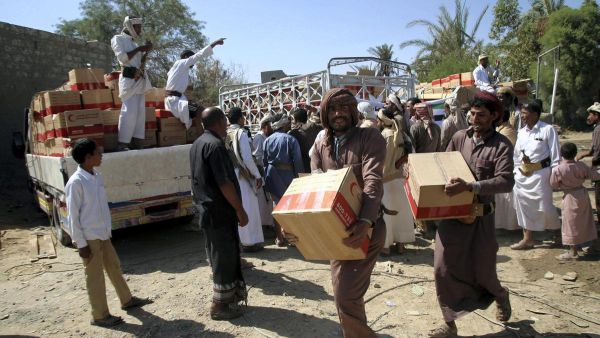 Yemenis carry boxes of food aid provided by the UAE Red Crescent for displaced people in the city of Marib. (Abdullah Al Qadry / AFP)