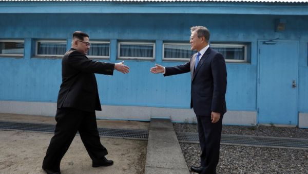 North Korea's leader Kim Jong Un (L) shakes hands with South Korea's President Moon Jae-in (R) at the Military Demarcation Line that divides their countries ahead of their summit at the truce village of Panmunjom on April 27, 2018. (AFP PHOTO)