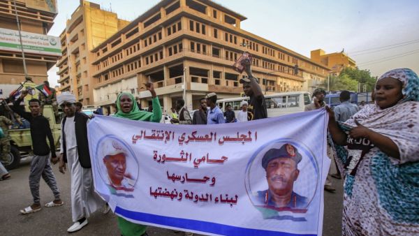 Sudanese supporters of the ruling Transitional Military Council (TMC) march with a banner showing the portraits of council chief General Abdel Fattah al-Burhan (R) and General Mohamed Hamdan Dagalo "Hamidati" (L). (AFP/ File)