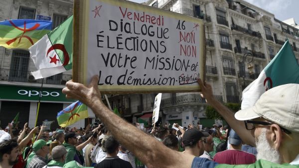 An Algerian protester holds a banner reading "your mission is dismissal" during a demonstration in the capital Algiers on June 7, 2019. Interim Algerian president Abdelkader Bensalah on June 6 called for "dialogue" after the authorities ruled out holding a planned election on July 4. (RYAD KRAMDI / AFP)